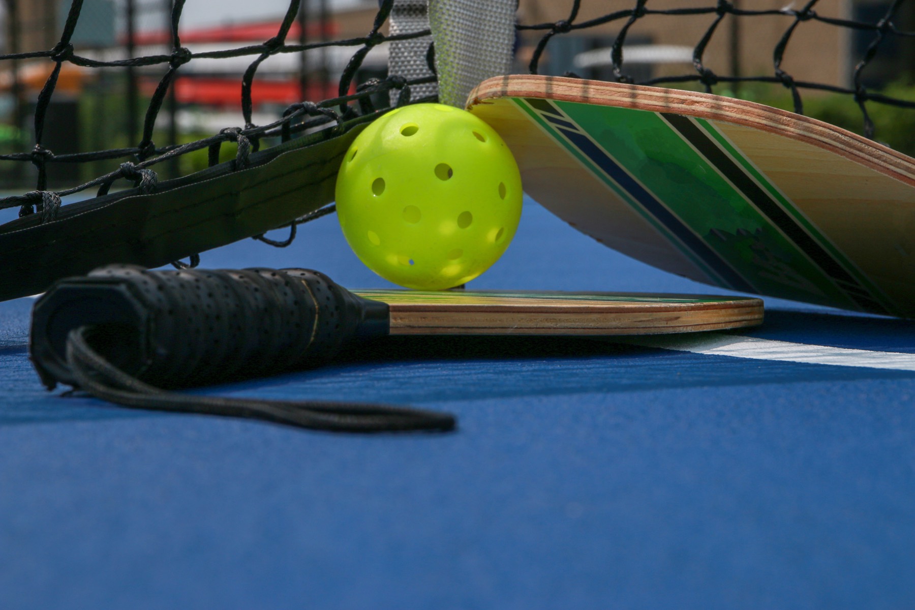 Pickleball paddles and ball on a court